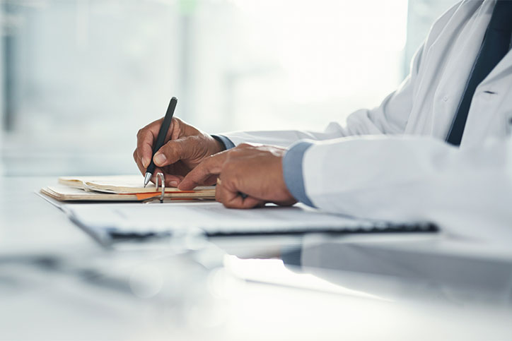 doctor writing notes with focus on hands Michigan doctors writes medical notes
