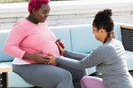 A photo of a pregnant person and a doula